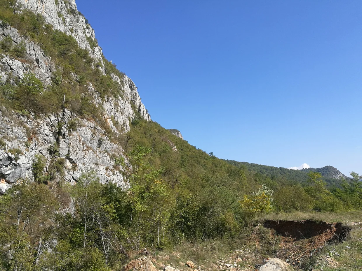Rocky cliff face rising above the gorge, Herzegovina's raw limestone landscape