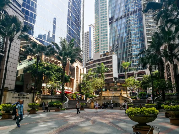 Modern Hong Kong Central district plaza with palm trees and glass skyscrapers