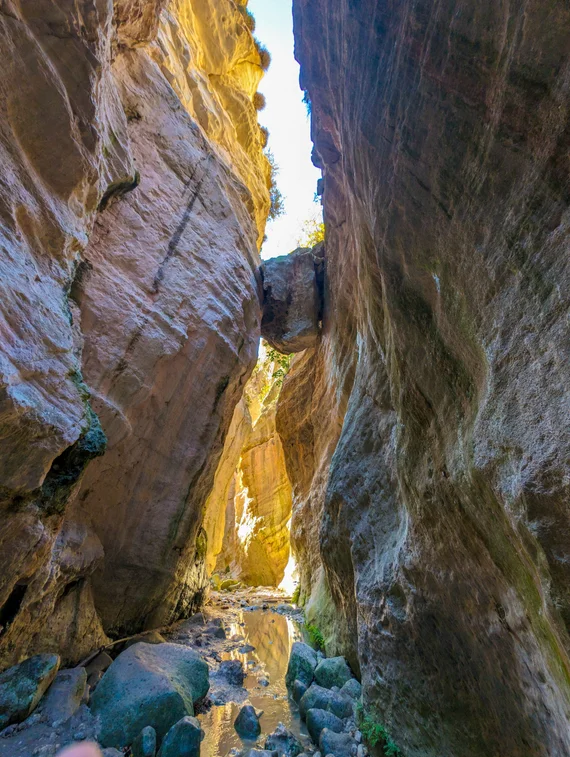 Looking upward through the narrow gorge with a chockstone wedged between walls