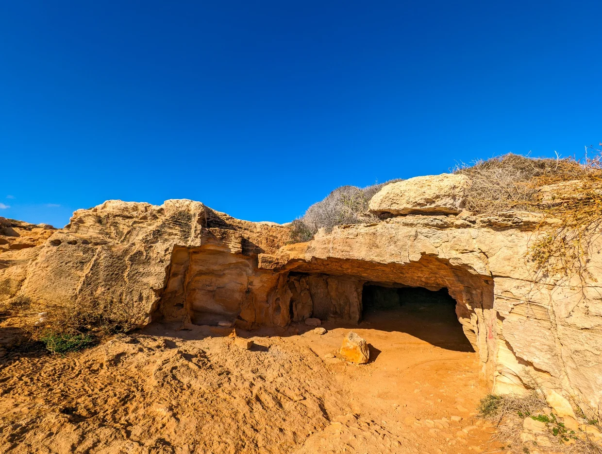 Sandstone cave entrance carved into golden-colored rock