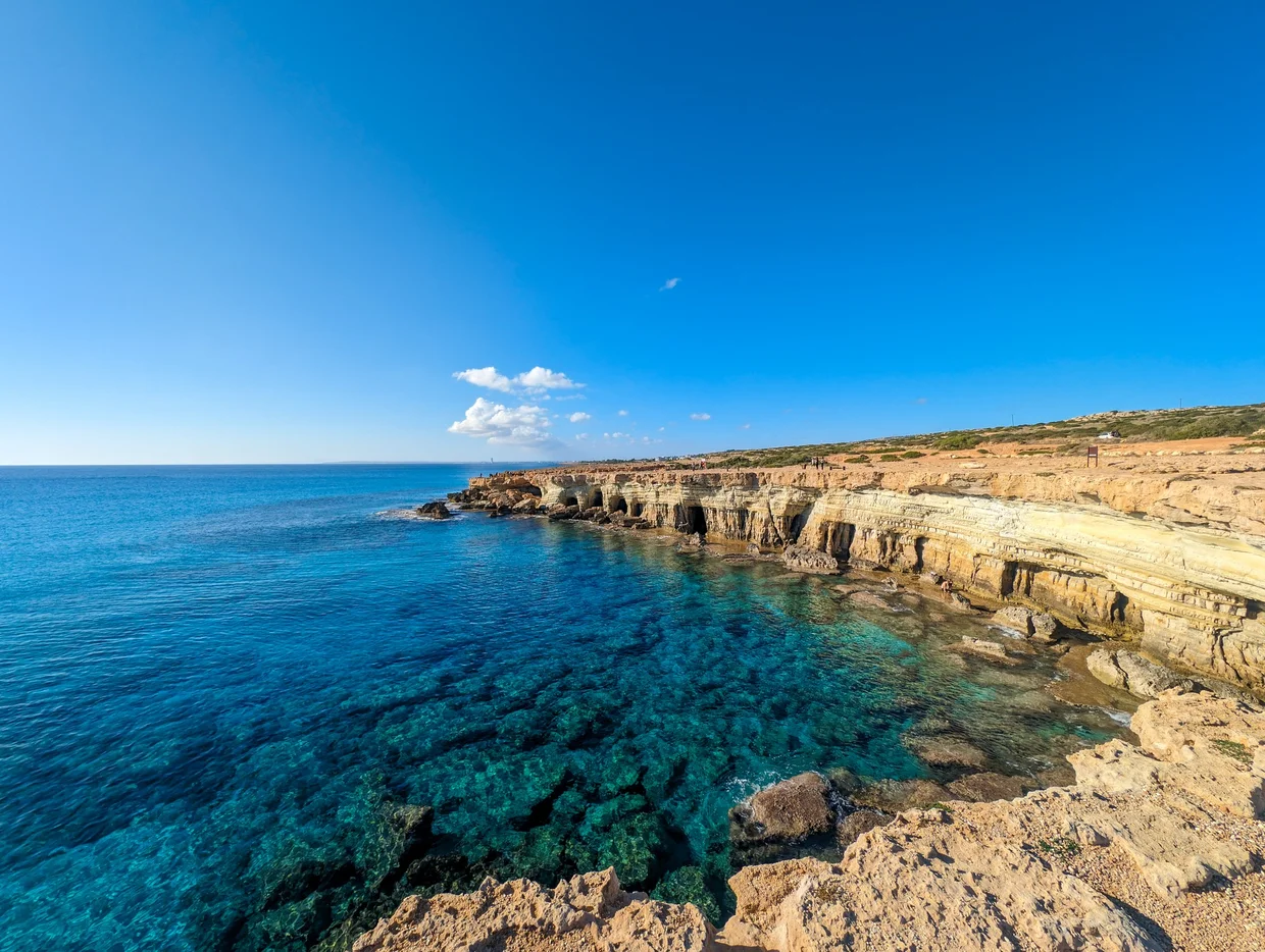 Panoramic view of the Cape Greco coastline with turquoise water and eroded cliffs