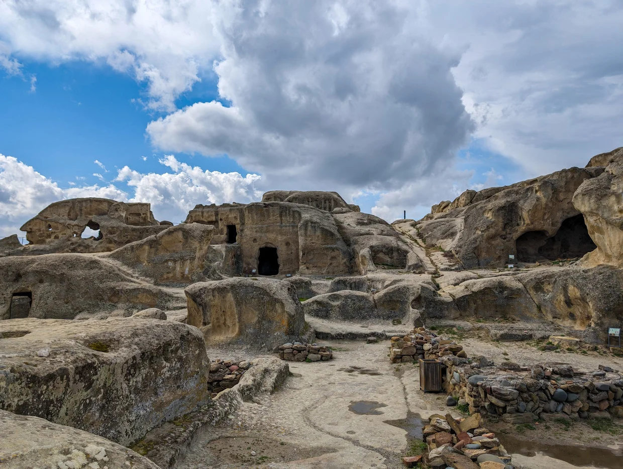 Uplistsikhe cave city carved into a sandstone cliff, the river valley below