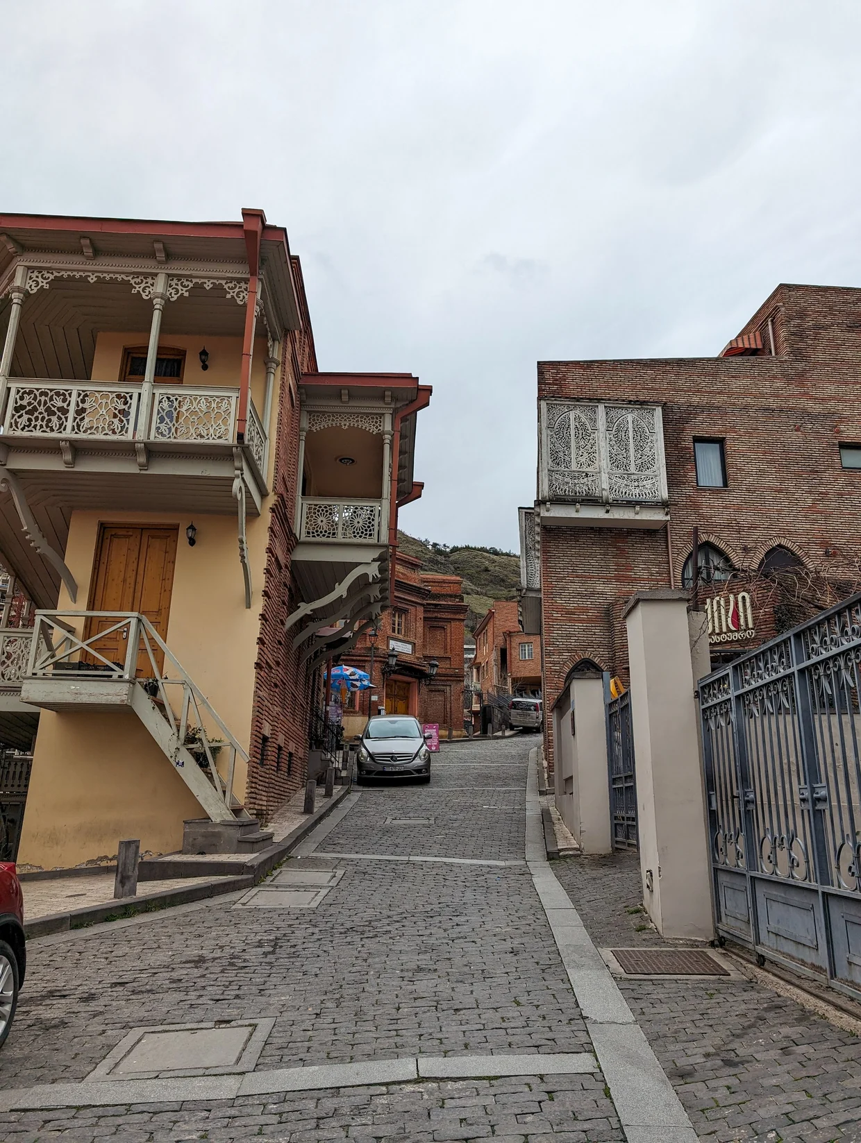 Cobblestone street in Old Tbilisi with carved wooden balconies