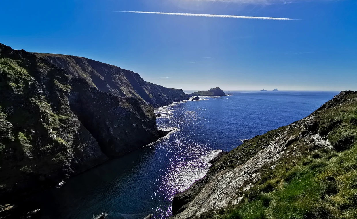 Dramatic sea cliffs with the Skellig Islands visible on the horizon