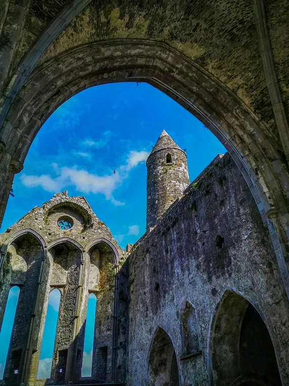 Round tower and Romanesque arches seen through a Gothic doorway