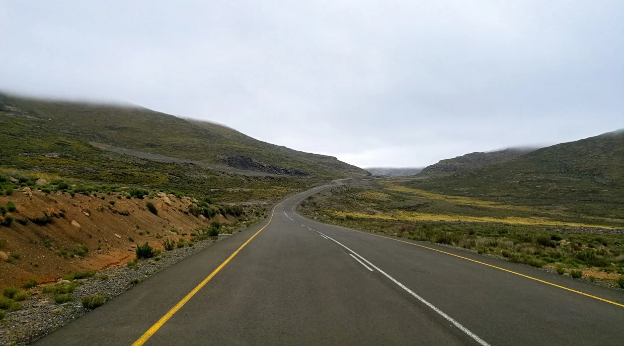 Mountain road disappearing into low clouds