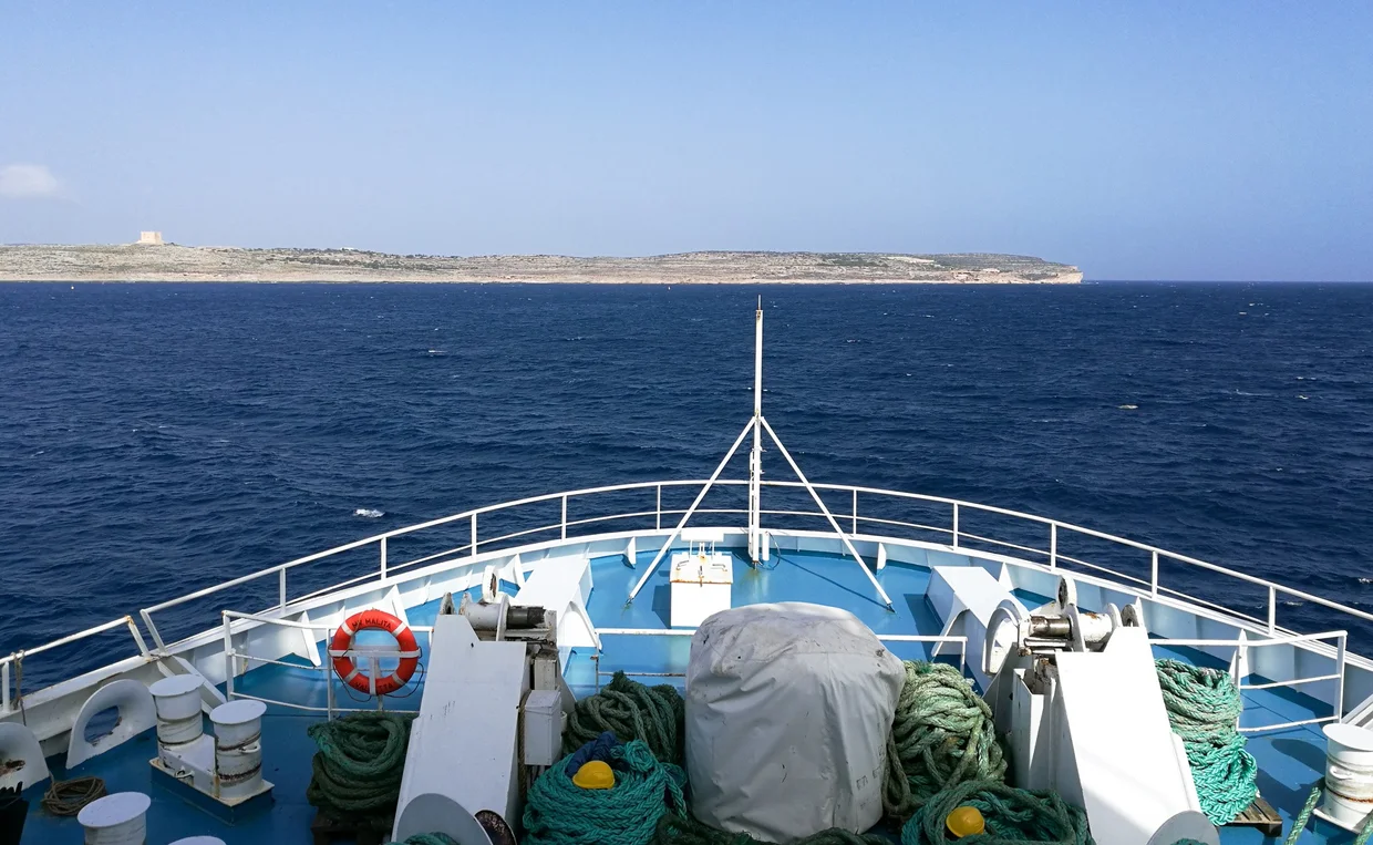 Ferry bow approaching the island with a watchtower visible ahead