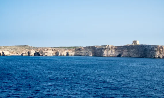 Dramatic limestone sea cliffs with caves at the base