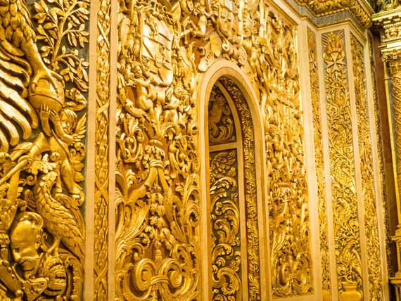 Extreme close-up of intricate gold leaf relief carving