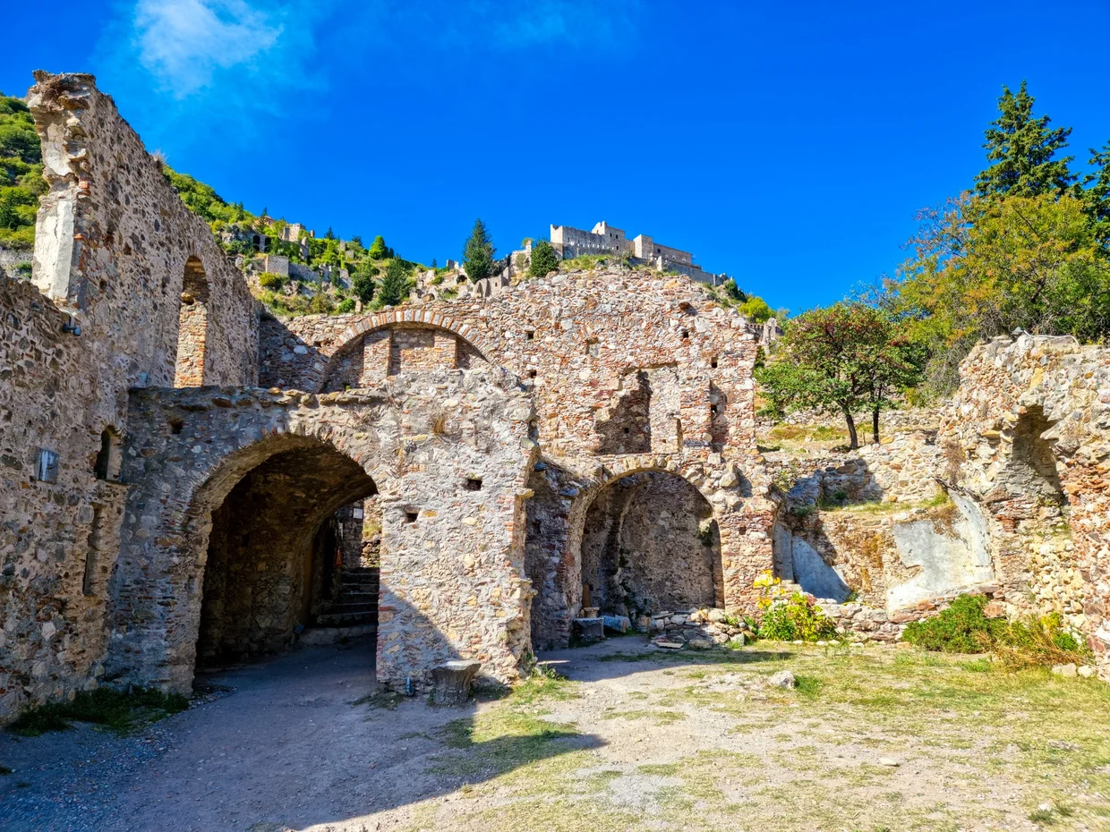 Ruined Byzantine buildings of Mystras with a castle on the hill above