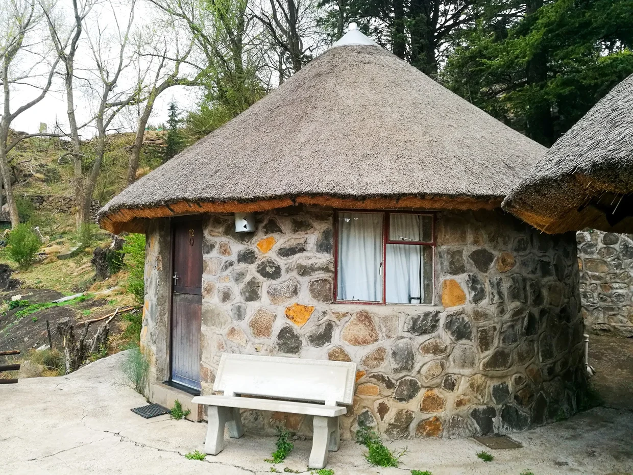 Round stone rondavel with thatched roof at Semonkong Lodge
