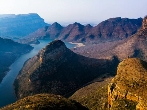 Blyde River Canyon with winding river and dramatic mountain cliffs at golden hour