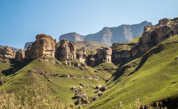 Sandstone rock formations and green hills in the Sani Pass area