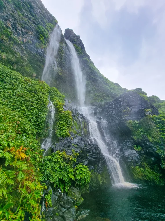 Waterfall plunging into a green pool