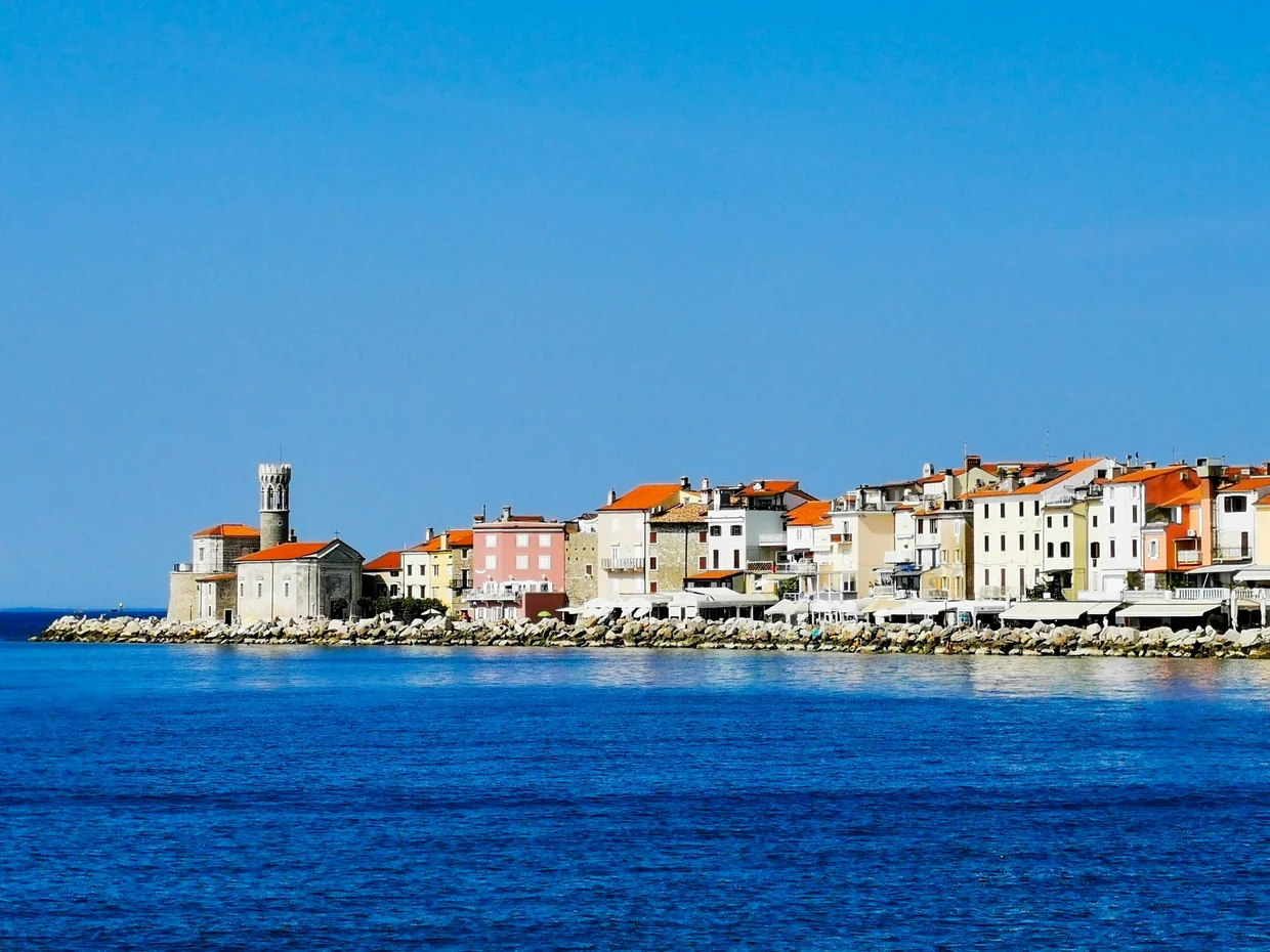 Piran seen from the water with the church tower on the hill
