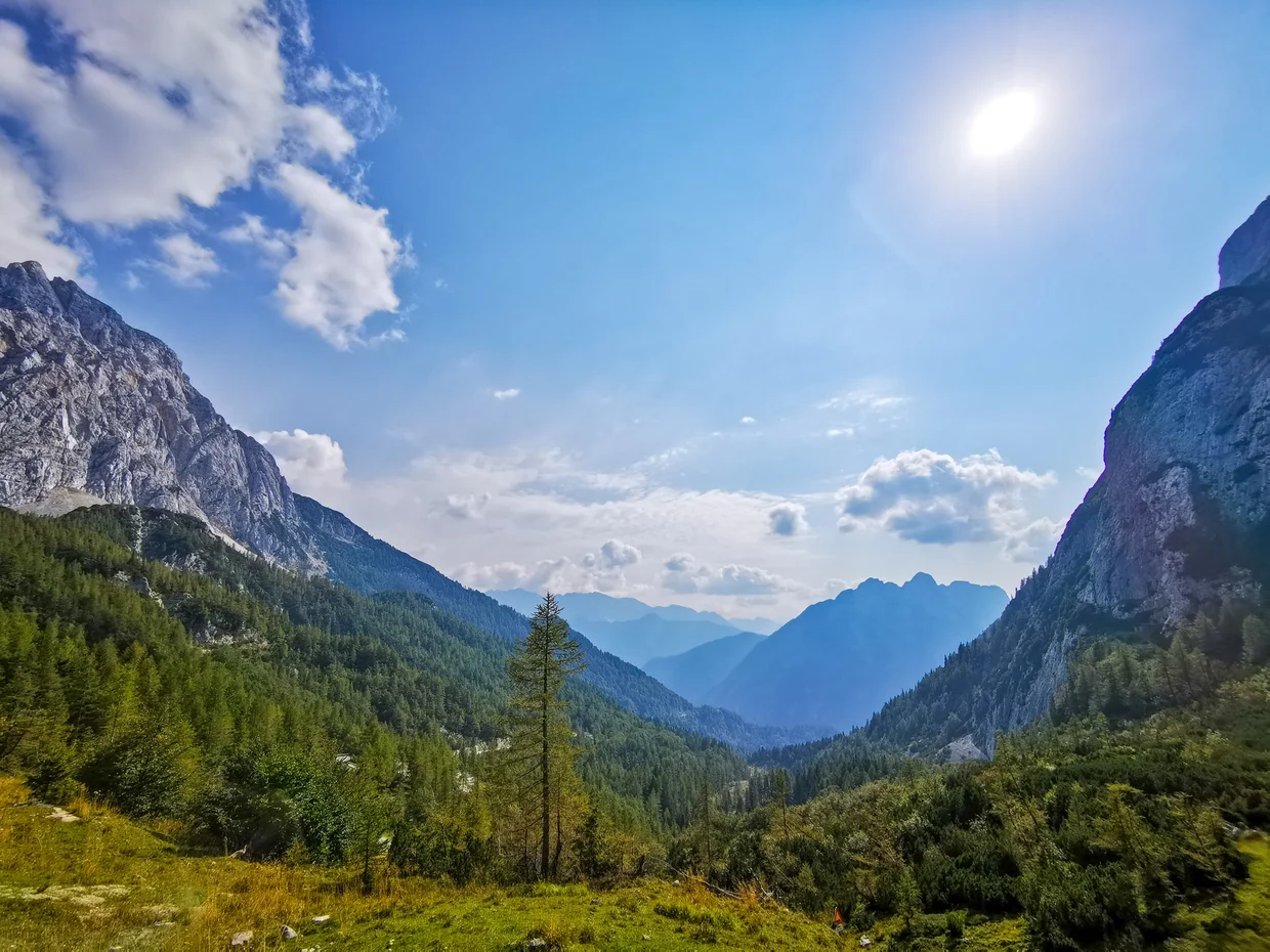 Long mountain valley with bright sky and sun