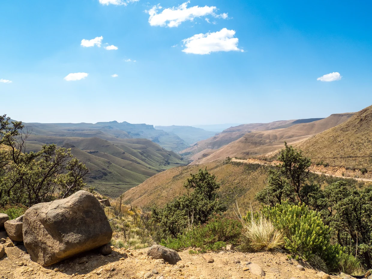 View down the valley from the Sani Pass road, rocky foreground and mountains beyond