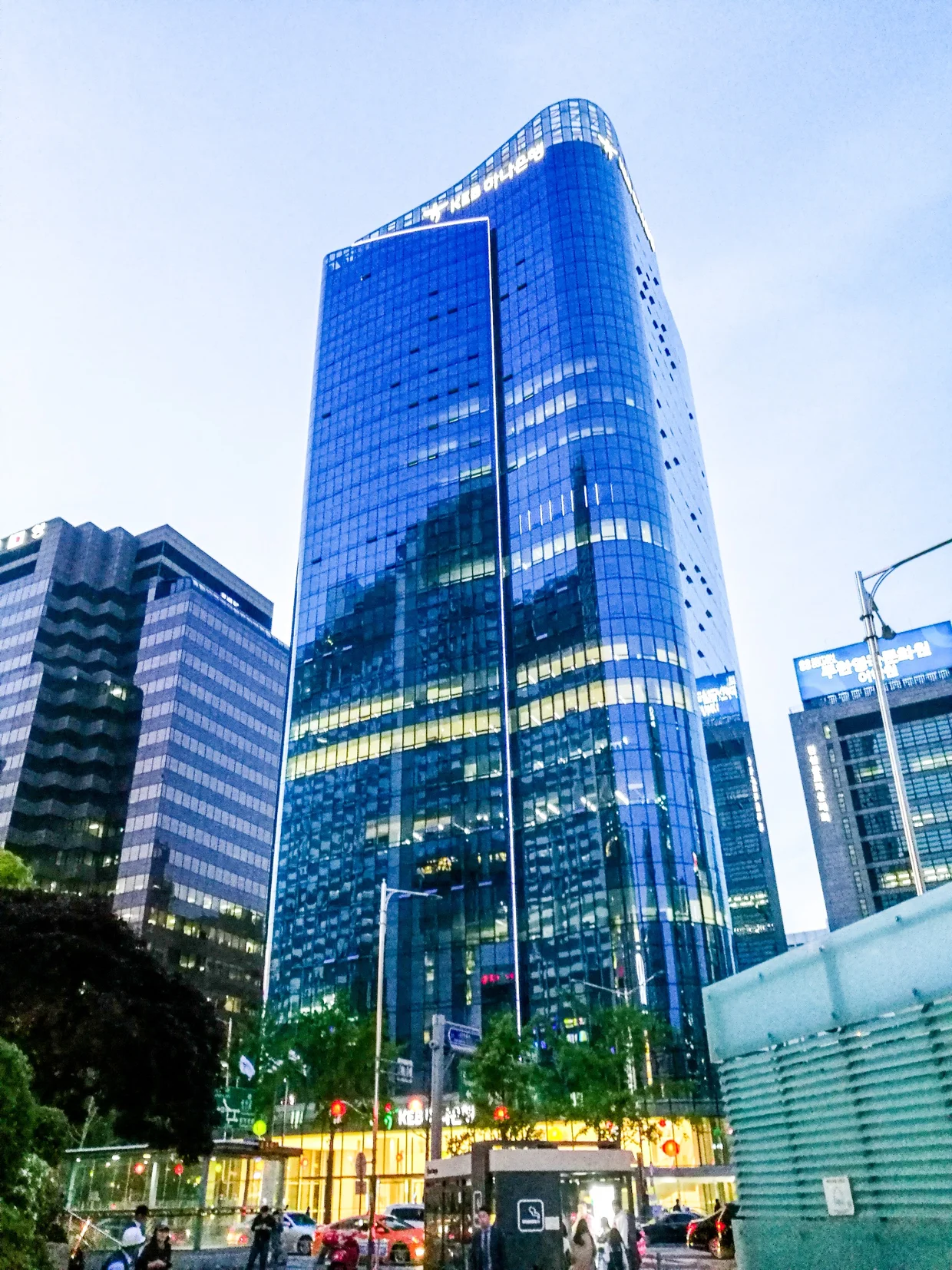 Blue glass skyscraper at dusk in Seoul's business district