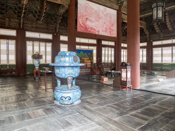 Palace interior with ornate blue ceramic vessel and painted ceiling