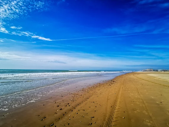 Wide empty beach under blue sky
