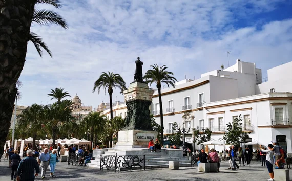 Plaza with statue and palm trees in Cádiz