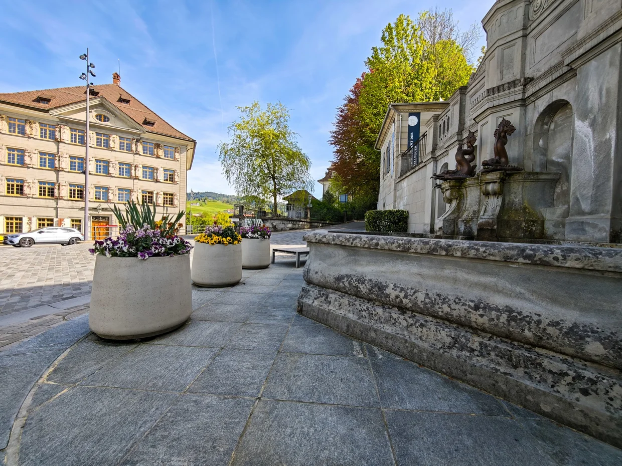 Cobblestone foreground with planters in front of the merchant mansion