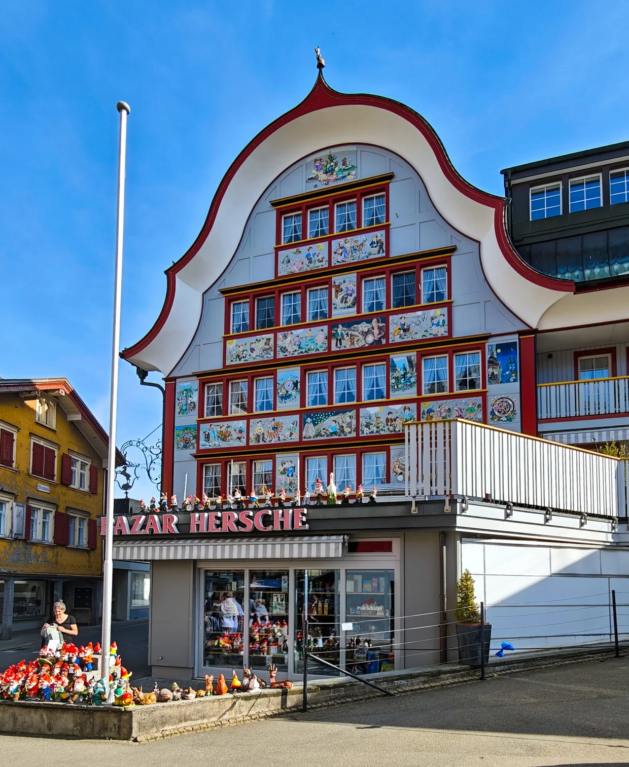 Bazar Hersche shop with painted facade and a row of Appenzeller dwarf figurines out front