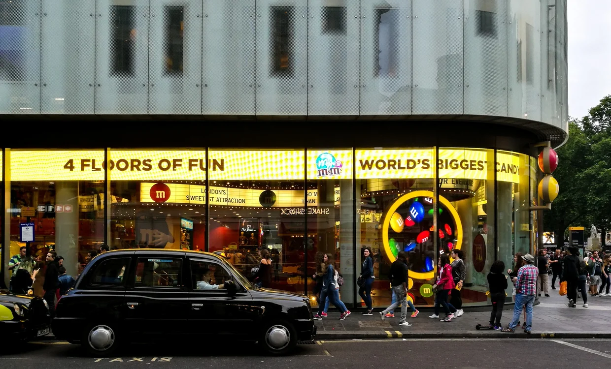 M&M's World storefront on Leicester Square, a black London cab parked in front