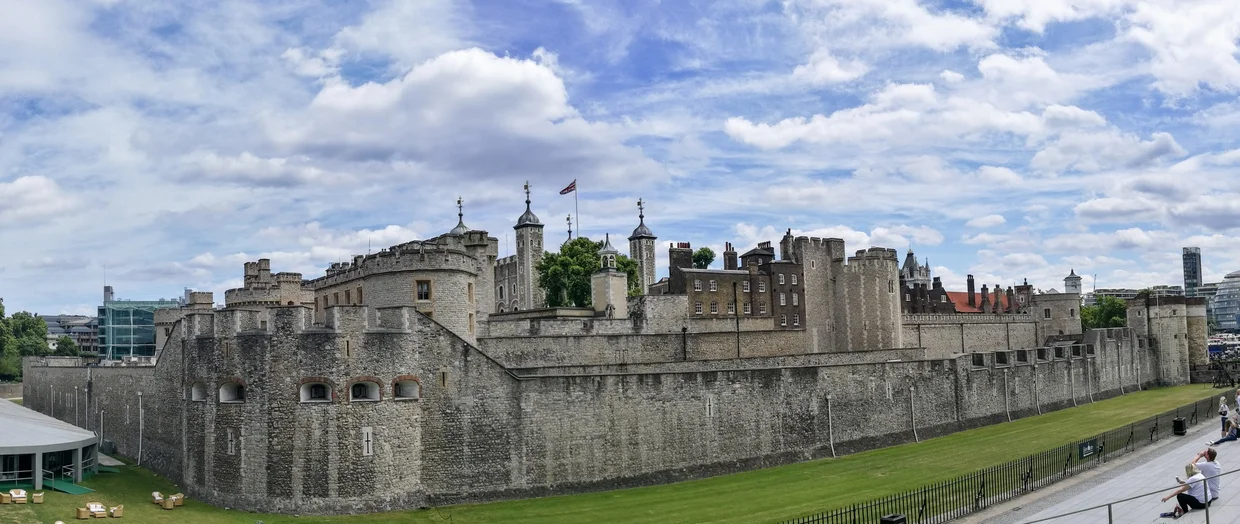 The Tower of London panoramic view, stone walls and turrets under a blue sky