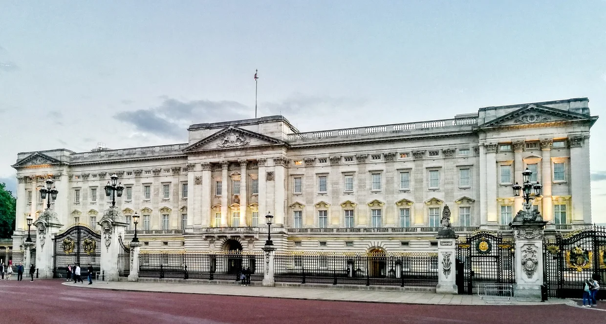 Buckingham Palace facade at dusk, windows glowing warm