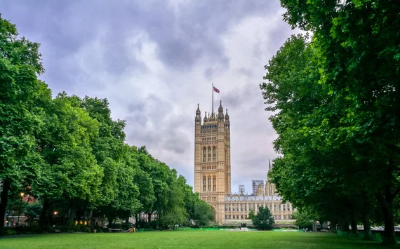 Victoria Tower framed by lush green trees in the gardens below