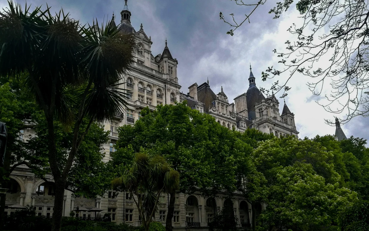 Grand Victorian building framed by trees and clouds